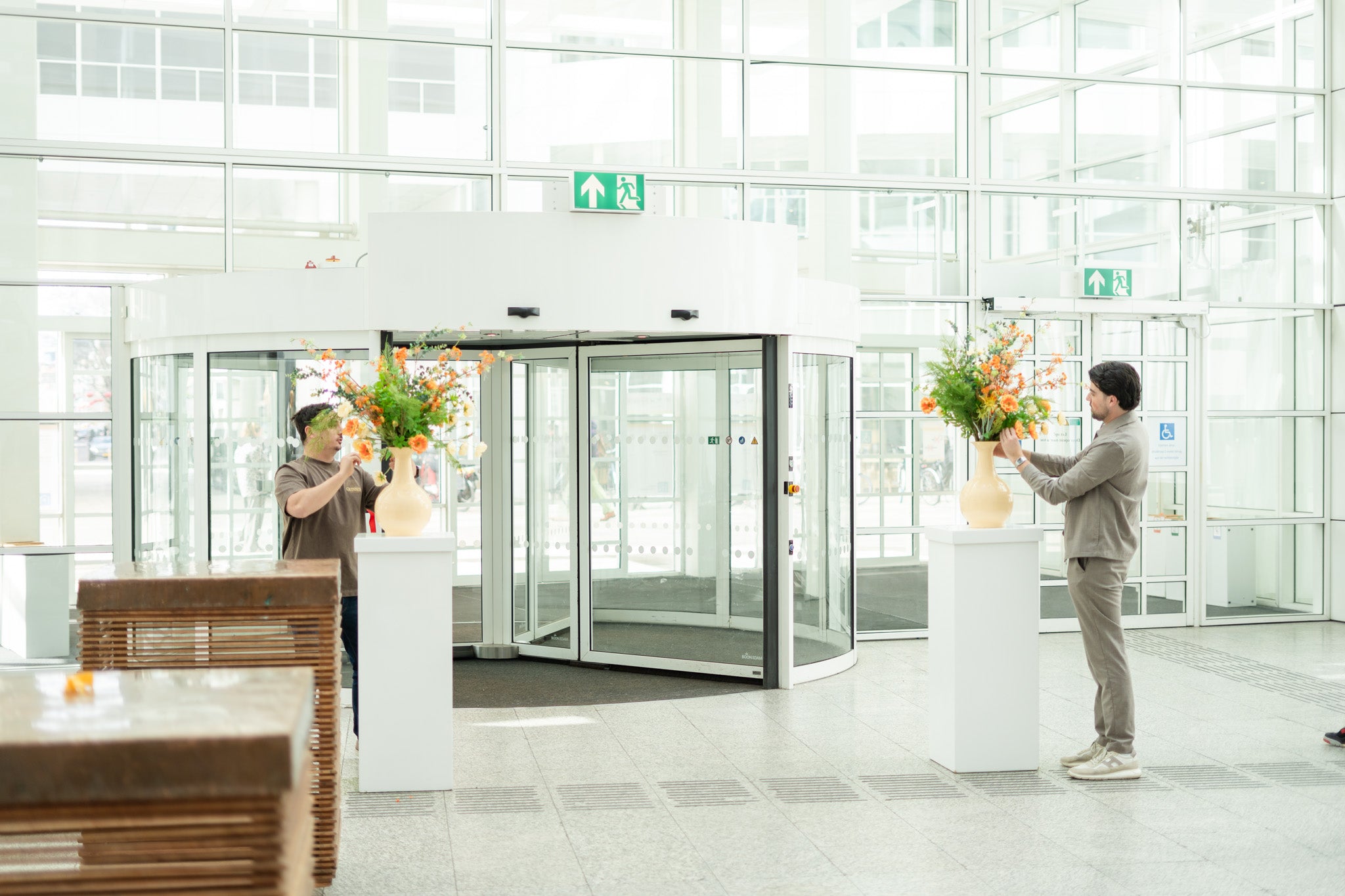 Kunstbloemen op zuilen in een glazen entreehal
