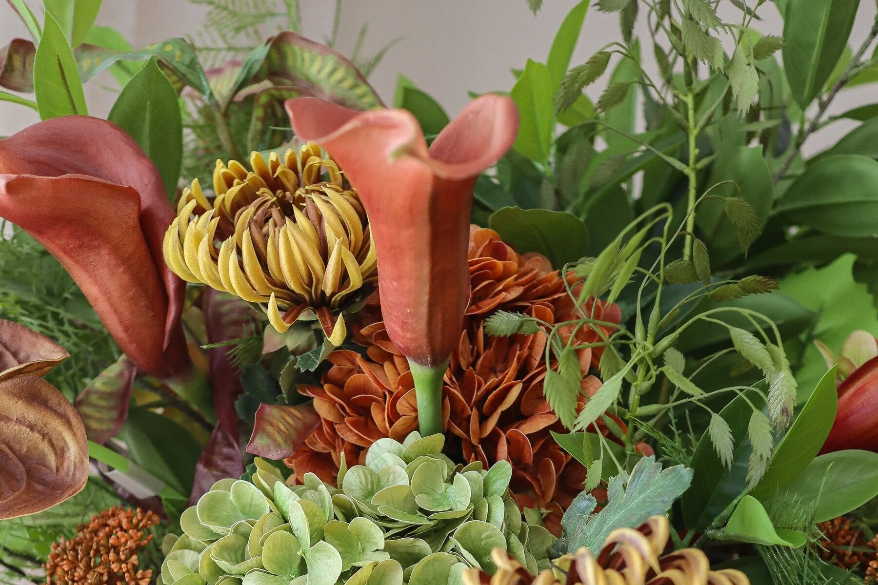 Groot kunstbloemen boeket in een donkere vaas