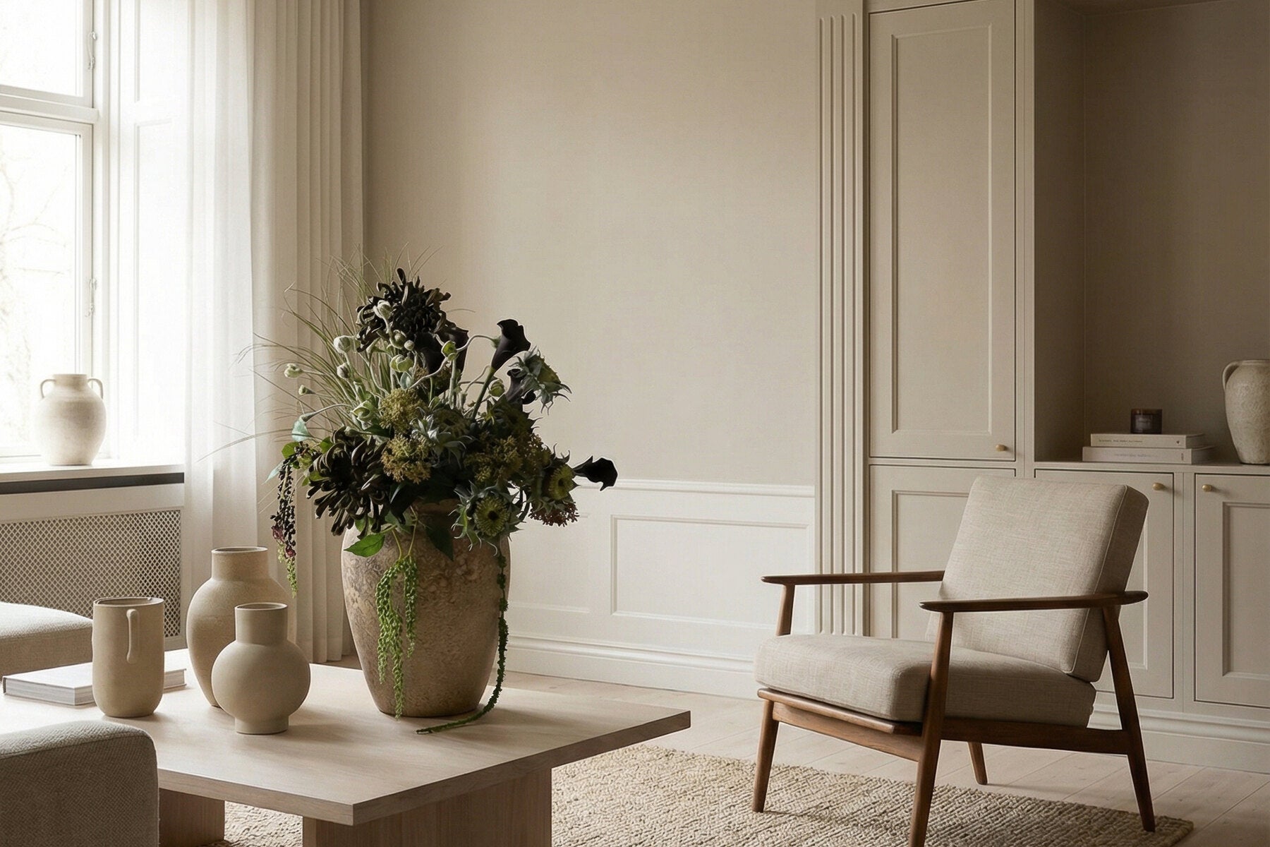 Zijden bloemen in vazen in een licht interieur met houten stoel