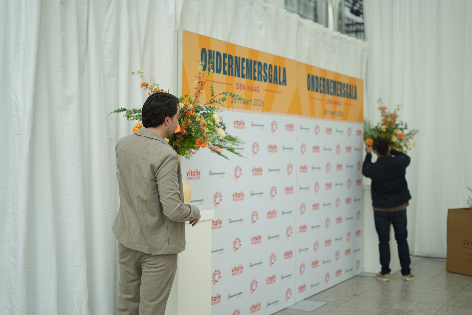 Bloemenarrangement bij een sponsorwand op een zakelijk event